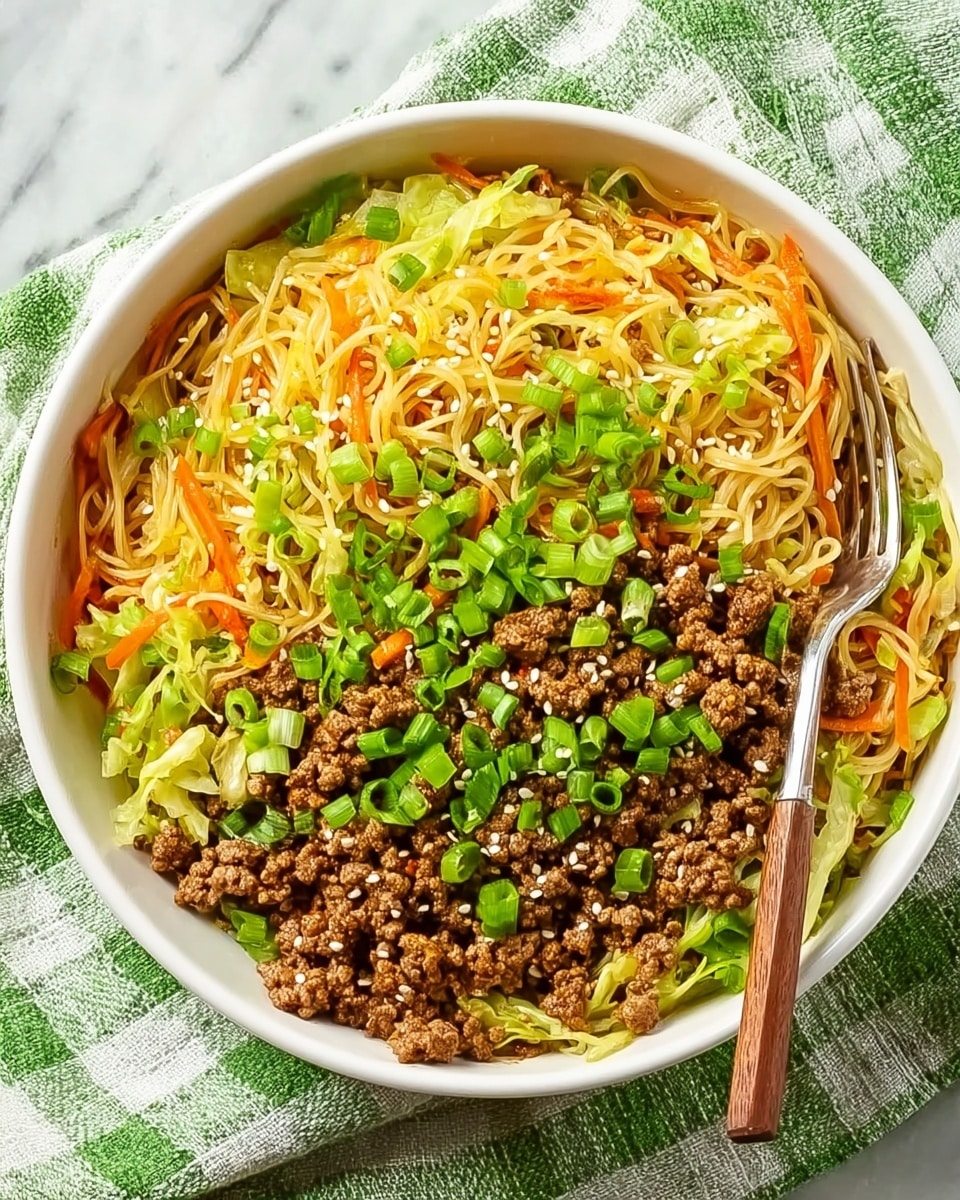 This image shows a white bowl filled with a colorful stir-fry dish. The bottom layer consists of thin yellow noodles mixed with thin strips of light green cabbage and small pieces of orange carrot. On top of this, there is a generous layer of brown cooked ground meat scattered evenly. The dish is garnished with bright green chopped spring onions and a sprinkling of white sesame seeds. A silver fork with a wooden handle is placed inside the bowl, resting on the noodles. The bowl sits on a green and white checkered cloth, all set against a white marbled surface. Photo taken with an iphone --ar 4:5 --v 7