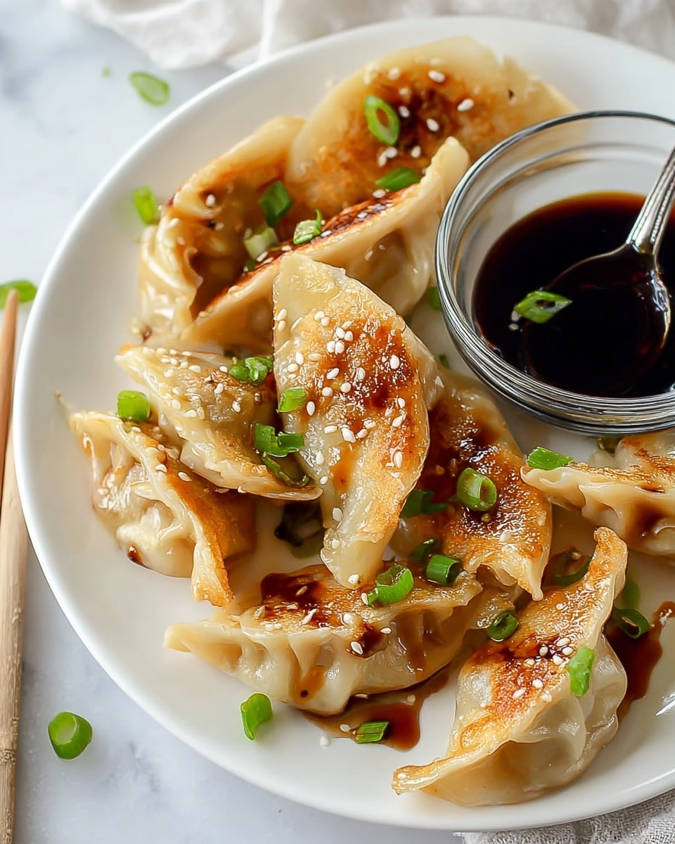 The image shows a white plate filled with several pan-fried dumplings that have a slightly golden and crispy texture on their edges and a soft, translucent dough on top. Each dumpling is drizzled with a glossy dark soy sauce, sprinkled with small white sesame seeds, and topped with bright green chopped scallions. In the background, there is a small clear glass bowl filled with dark soy sauce, and a spoon rests inside it. The whole setup is placed on a white marbled surface, giving a clean and fresh look. photo taken with an iphone --ar 4:5 --v 7