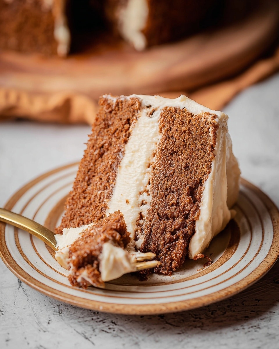 A close-up image of a two-layer brown cake slice with a light cream frosting layer in the middle and a thick layer of the same frosting on the side of the cake. The cake looks soft and crumbly, with bits of cake texture visible. A small piece of cake with cream frosting is held close on a gold fork in the foreground. The slice is on a white plate with light brown rings, placed on a white marbled textured surface. Photo taken with an iphone --ar 4:5 --v 7