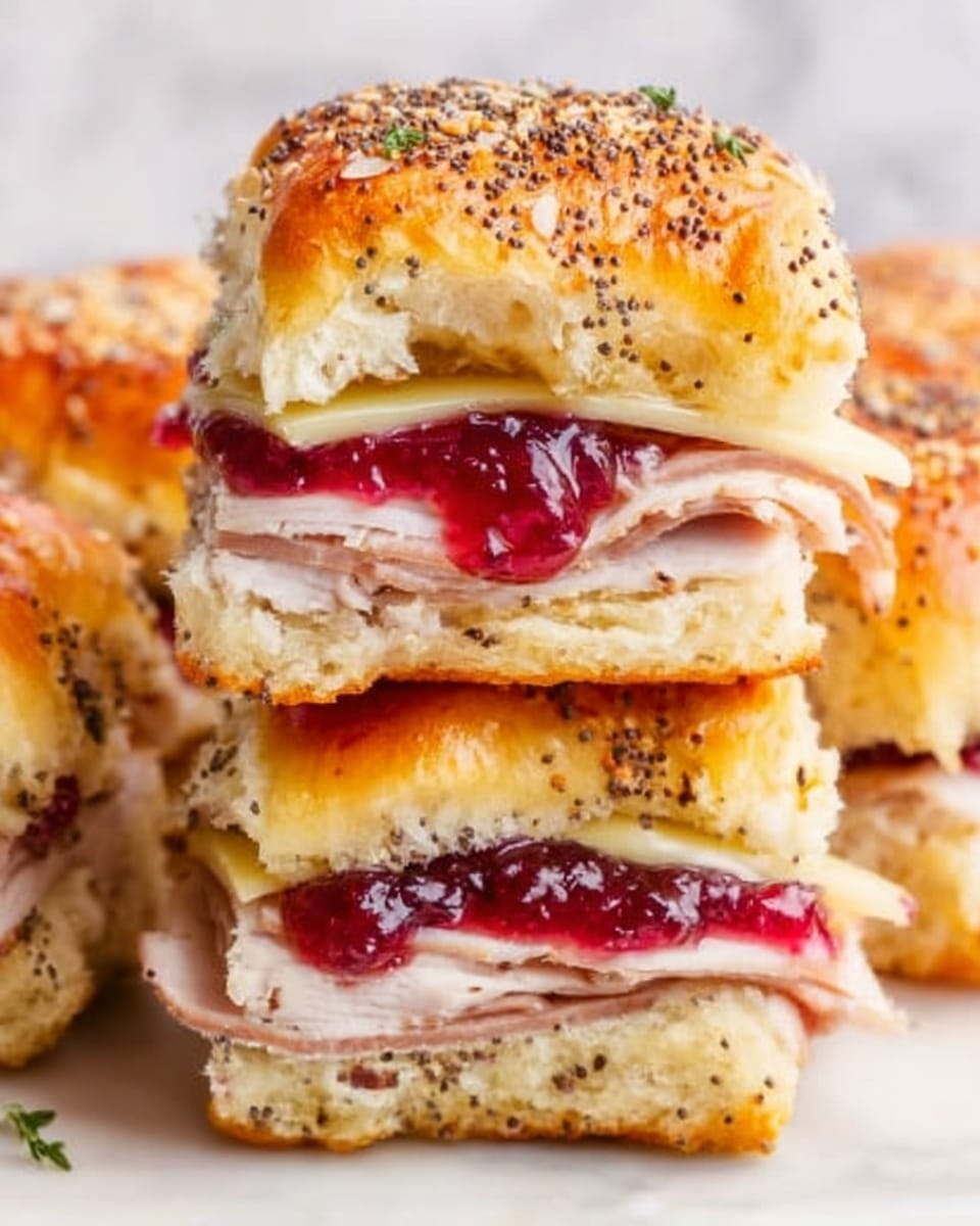 The image shows three sandwich pieces stacked unevenly on a white marbled surface. Each sandwich has a top layer of a golden brown bun with poppy seeds and other small seeds sprinkled on it. Below the bun is a layer of soft, light yellow cheese that looks melted. Under the cheese is a thick slice of light pink turkey meat. Below the meat is a bright red sauce or jelly, slightly glossy in texture. The sandwiches are cut to show all these layers clearly, highlighting the textures of soft bread and moist fillings. Photo taken with an iphone --ar 4:5 --v 7