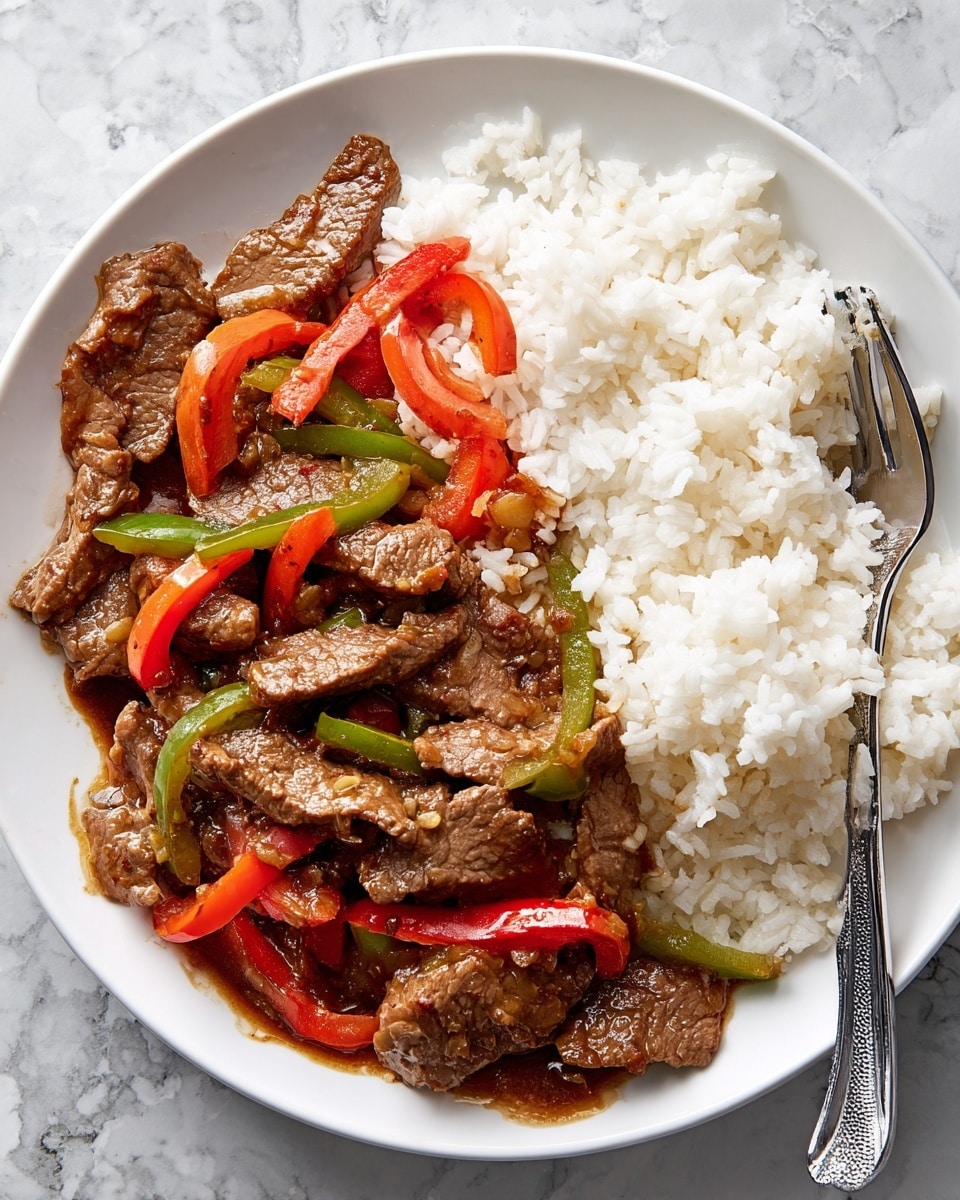 The dish shows a white plate filled with two main parts: on one side, white steamed rice with a soft, slightly fluffy texture; on the other side, stir-fried beef slices topped with glossy brown sauce and mixed with red and green bell pepper slices, giving a colorful contrast. The beef pieces are brown with a slightly shiny texture from the sauce, while the bell peppers add bright reds and greens, cut into small strips scattered evenly over the beef. A silver fork rests on the right side of the plate, partially placed in the rice and beef mixture. The background is a white marbled texture. Photo taken with an iphone --ar 4:5 --v 7