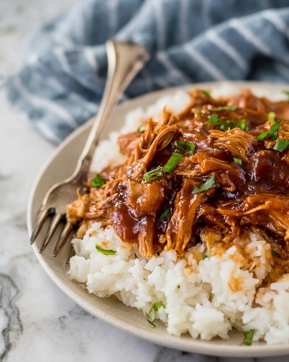 The image shows a close-up of a dish with two main layers on a white plate: the base layer is white cooked rice with a fluffy texture, and the top layer is a glossy, brown shredded meat covered in thick sauce with small green garnish pieces. A silver fork is partially inserted into the rice and meat, resting on the plate's edge. The background features a white marbled texture with a blurred blue and white striped cloth nearby. photo taken with an iphone --ar 4:5 --v 7