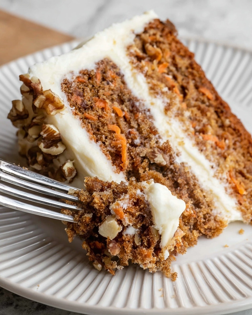 A close-up of a slice of carrot cake on a white plate with ridged edges, showing two thick layers of moist, brown cake filled with small pieces of carrot and nuts. Between the layers is a smooth, thick white cream cheese frosting, which also covers the sides of the cake. The frosting on the side is decorated with chopped walnuts, adding texture and color contrast. A silver fork is cutting into the cake, holding a small piece with frosting on it. The whole scene is set on a white marbled texture surface. photo taken with an iphone --ar 4:5 --v 7