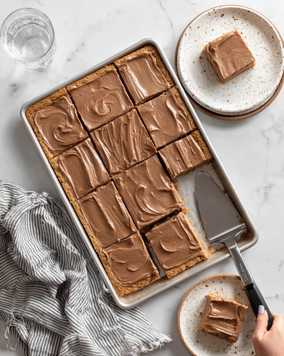 A large metal baking tray holds a square bar dessert cut into twelve pieces. The bottom layer is a golden, crumbly cookie crust, topped with a thick, smooth layer of light brown chocolate frosting spread evenly with visible swirled texture. Four pieces have been lifted from the tray and placed nearby, one on a white plate with a brown patterned rim and one in a woman's hand. A metal spatula with a black handle rests under one removed bar. The scene is set on a white marbled surface with a clear glass of water nearby and a white plate with brown speckles partially visible. A gray striped cloth is draped at the edge of the tray. Photo taken with an iphone --ar 4:5 --v 7